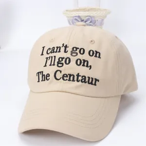 Detail of embroidered quote on beige cotton baseball cap with curved brim design