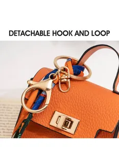 Detail of orange lychee leather mini bag charm with silk scarf and gold twist lock