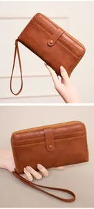 Close-up of vintage brown leather wallet with multiple card slots and wristlet strap