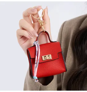 Detailed macro view of red lychee leather mini bag keychain with floral silk scarf detail