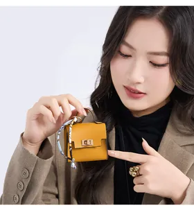 Mini yellow leather bag charm with golden lock and floral scarf on a keychain