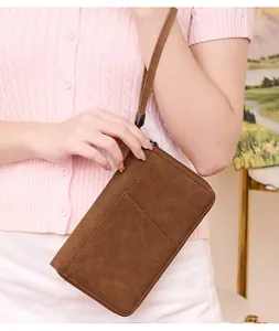 Detail of vintage brown RFID passport wallet with textured surface and wrist strap