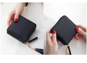 Detail of black square zip wallet with textured leather finish and tassel zipper pull