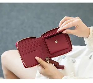 Macro detail of the wine red short wallet interior with card slots and tassel zipper