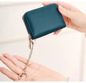 Detailed macro view of teal lychee textured leather coin purse with metal keychain