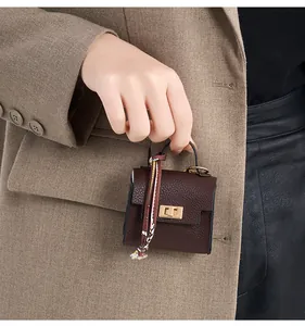 Detail of mini leather handbag charm with silk scarf handle and golden metal lock