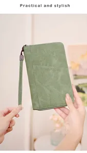 Green RFID passport wallet with zip closure and wrist strap held by hands