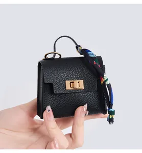 Miniature black pebble leather bag charm with colorful silk scarf and gold lock detail