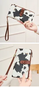 Détail d'un portefeuille motif vache avec protection RFID et dragonne en cuir