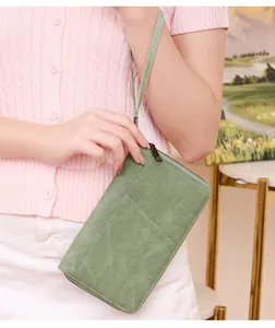 Close-up of sage green RFID passport wallet with suede texture and metal zipper detail
