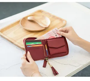 Detail view of red square zipper wallet showing interior card slots and tassel charm