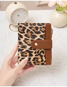 Detail of vintage leopard print and brown pebble leather wallet with snap closure