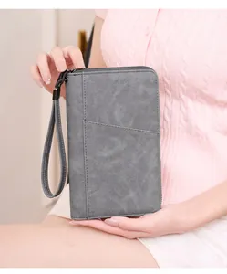 Detail of grey vintage RFID passport wallet featuring matte texture and wrist strap