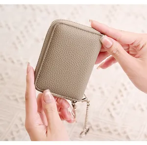 Detailed macro view of light khaki lychee pattern leather card holder with chain