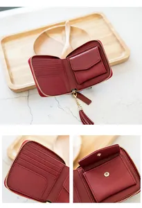 Detail of dark red zip-around leather wallet with tassel and interior card slots