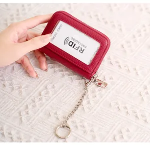 Burgundy litchi leather RFID card holder with zipper closure and metal keychain detail
