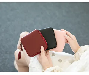 Detailed close-up of small square zip wallets in burgundy black and pink with tassels