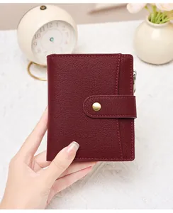 Close-up of wine red lychee grain leather wallet with golden snap and zipper detail