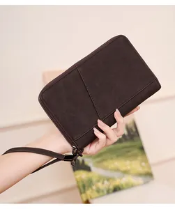 Detail of dark brown matte RFID passport wallet with zipper and wrist strap hand-held