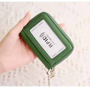Detail of green leather RFID card holder with zipper closure and silver chain hook
