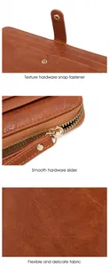 Close-up of golden hardware snap and zipper on vintage brown leather long wallet