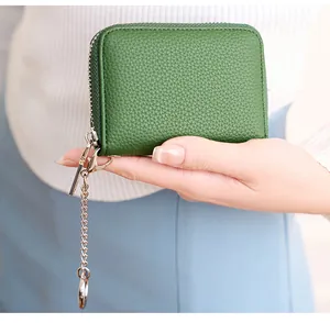 Detailed close-up of forest green litchi texture leather card holder with a metal chain
