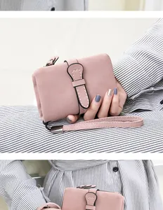 Detail of pink PU leather wallet with snap closure and wristlet strap on striped background