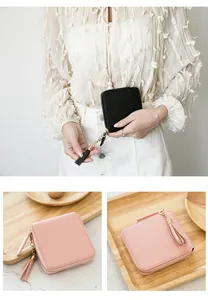 Detail of square zip wallet with tassel charm and textured faux leather in two colors