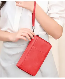 Gros plan d'un grand portefeuille passeport RFID rouge vintage tenu par un mannequin