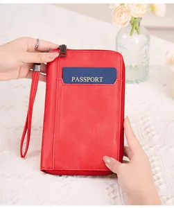 Gros plan du protège-passeport RFID en similicuir rouge avec fente et dragonne