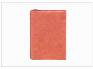 Détail de l'étui passeport RFID orange montrant la texture du cuir et les coutures