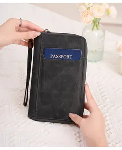 Détail d'un portefeuille de voyage RFID en cuir noir avec dragonne et fente passeport