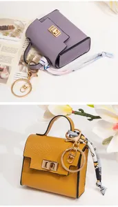 Miniature leather bag charms with silk scarves and golden keychains in purple and yellow