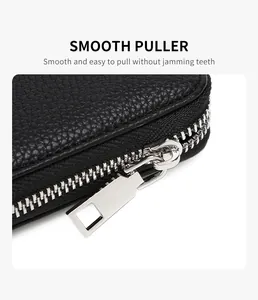 Close-up of premium black pebble leather wallet with smooth silver metal zipper detail