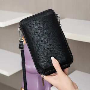 Détail du sac de téléphone noir en cuir grainé avec fermetures éclair argentées