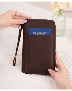 Détail du protège-passeport RFID en cuir marron foncé avec fente pour carte et dragonne