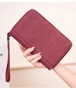 Macro view of burgundy RFID passport wallet detail with zipper and matte leather texture