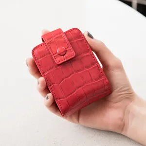 Red crocodile texture mini makeup pouch with mirror shown held in a woman's hand