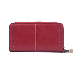 Red long zip-around leather wallet for women with decorative white stitching and cutouts