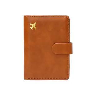 Brown RFID blocking passport holder in soft leather with gold plane icon and snap closure