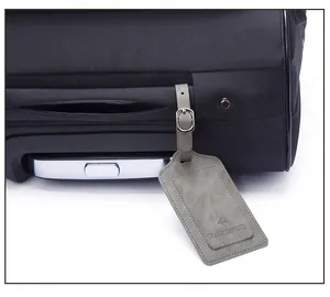 Detail of grey PU leather luggage tag with embossed airplane logo and adjustable buckle strap