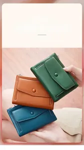 Dettaglio di portafogli compatti in pelle colorata con texture a grana e scomparti per carte