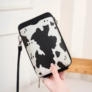 Détail du sac à bandoulière motif vache en cuir grainé avec fermeture éclair argentée