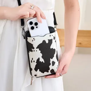 Détail du sac de téléphone à motif vache en cuir grainé contenant un grand smartphone
