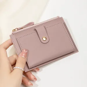 Gros plan détaillé d'un porte-monnaie rose en cuir avec fermeture éclair et bouton pression