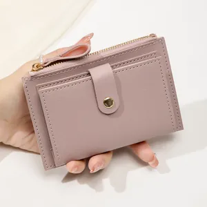 Gros plan d'un petit porte-cartes rose poudré avec fermeture éclair et texture cuir