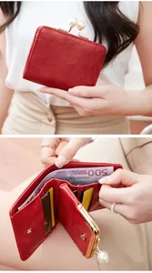 Détail d'un portefeuille rétro rouge en cuir avec fermoir perle et fentes de cartes
