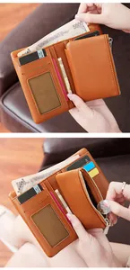 Détail d'un portefeuille en cuir marron avec fentes cartes, fenêtre ID et poche zippée