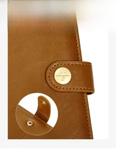 Exquisite details of brown leather passport holder with metal snap closure and engraving