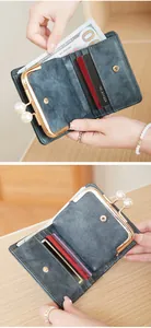 Détail d'un portefeuille vintage bleu foncé avec fentes pour cartes et fermoir perle
